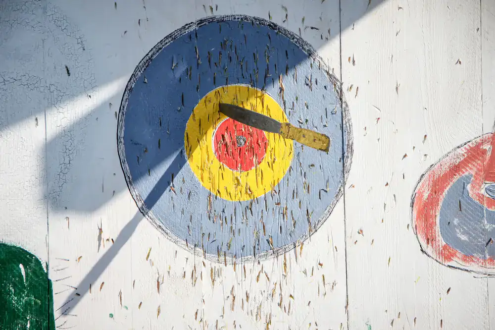 An axe embedded perfectly in the center of a wooden bullseye